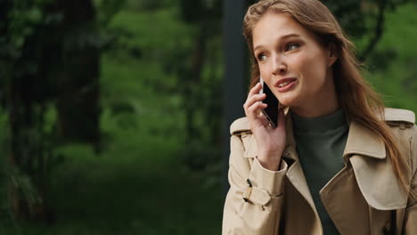 Caucasian-female-student-talking-on-the-phone-outdoors.