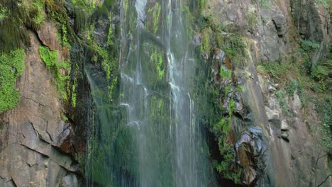 aguacaida waterfall on mossy cliffs in panton, lugo, spain