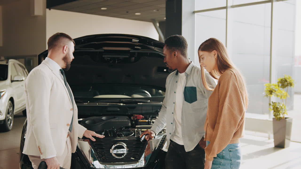 una pareja mirando un coche en una sala de exposiciones