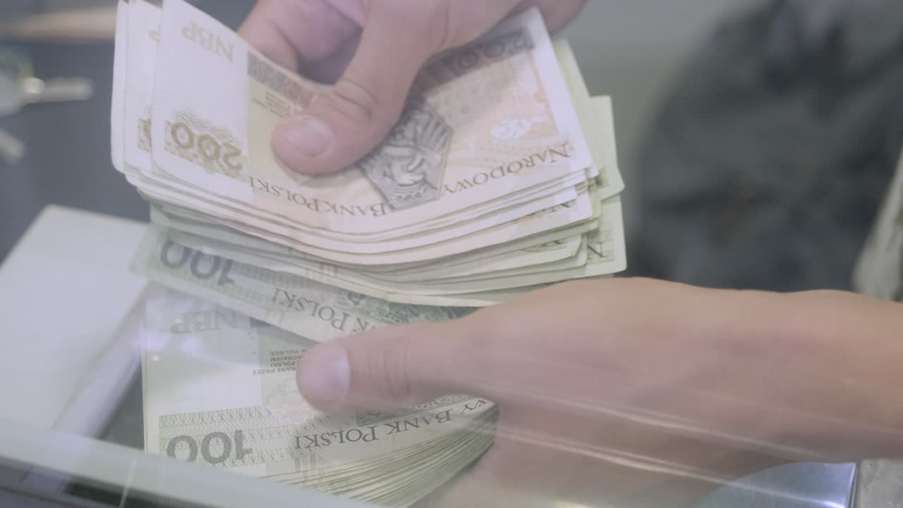 손은 폴란드 슬로티 지폐의 숫자를 계산합니다. 은행 현금 책상