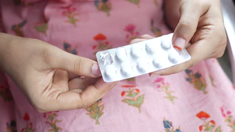 mujer sosteniendo un paquete de pastillas