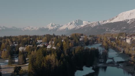 Rotierende-Antenne-über-Alpenhäusern-Am-Kalten-See-Des-Wunderschönen-Bergresorts-Crans-Montana,-Schweiz