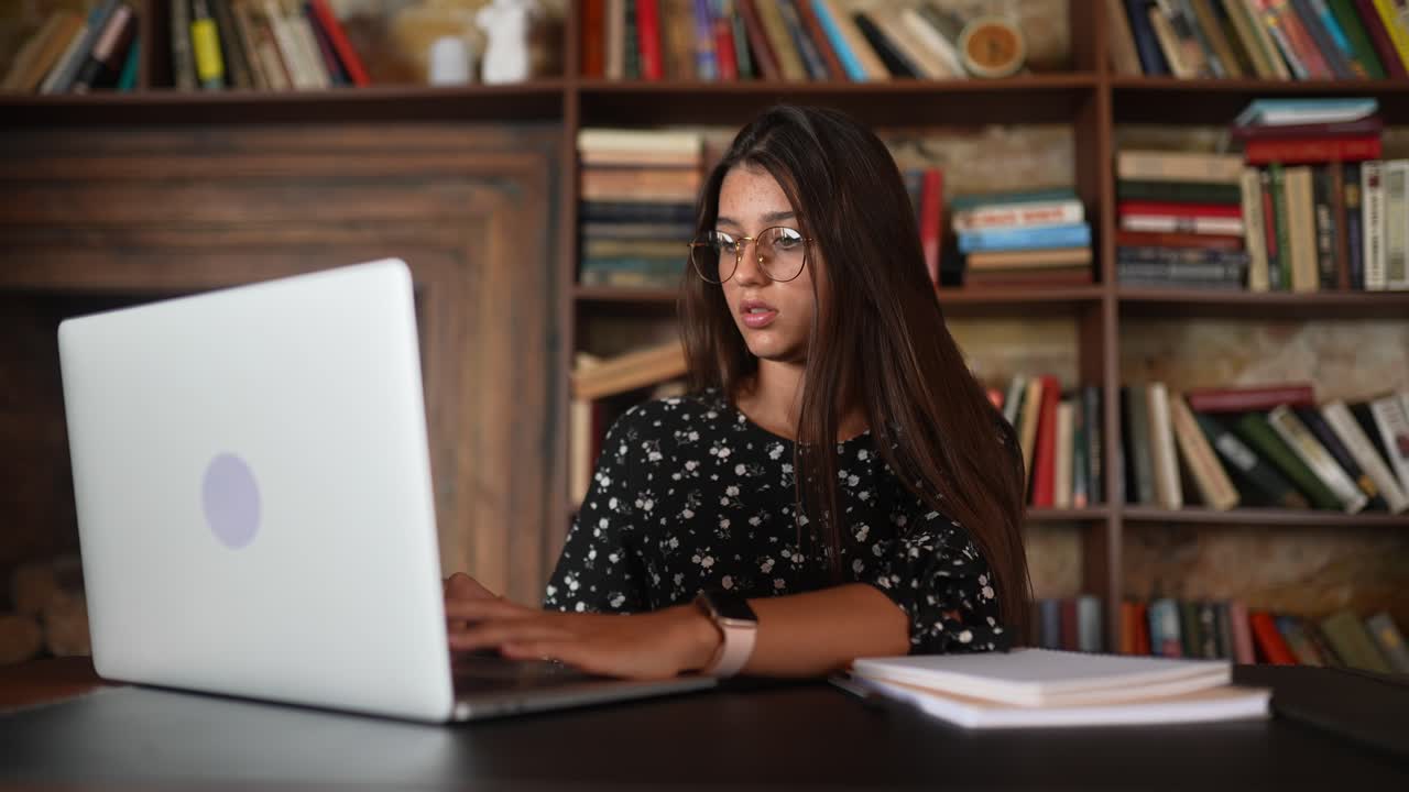 mujer trabajando en una computadora portátil en un café de la biblioteca