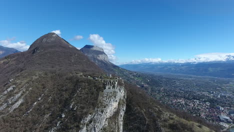 Vista-De-Drones-Volando-Hacia-La-Fortaleza-De-La-Bastilla-En-Los-Alpes-Franceses-De-Grenoble