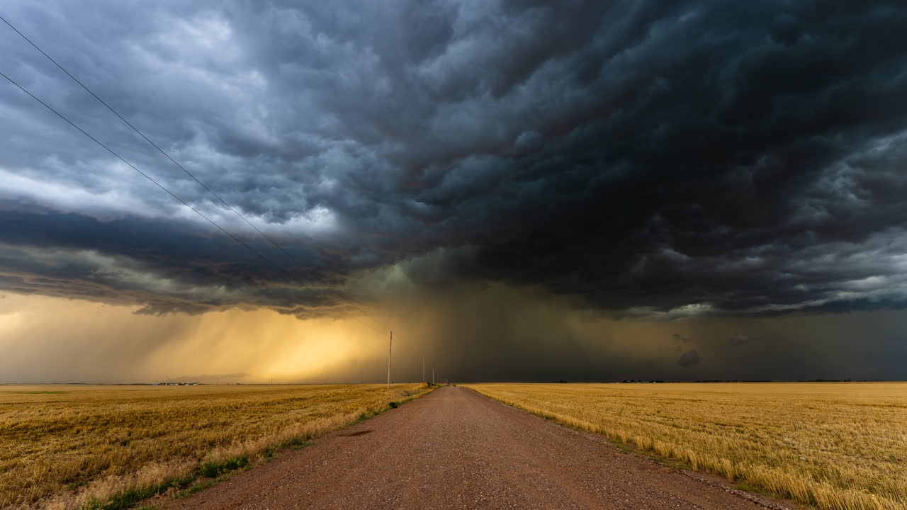 Dark storm clouds over a dusty country road with lightning striking