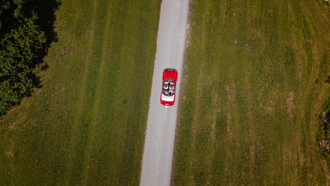 Vista aerea dall'alto di un'auto decappottabile rossa d'epoca che guida su una strada a Heutal, Austria. Volkswagen VW Maggiolino.