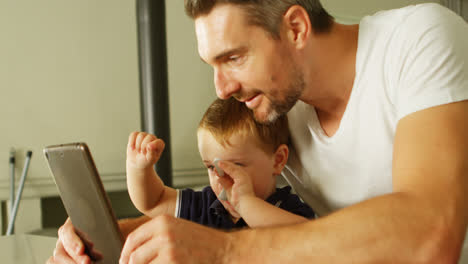 padre e hijo usando tableta digital en casa 4k