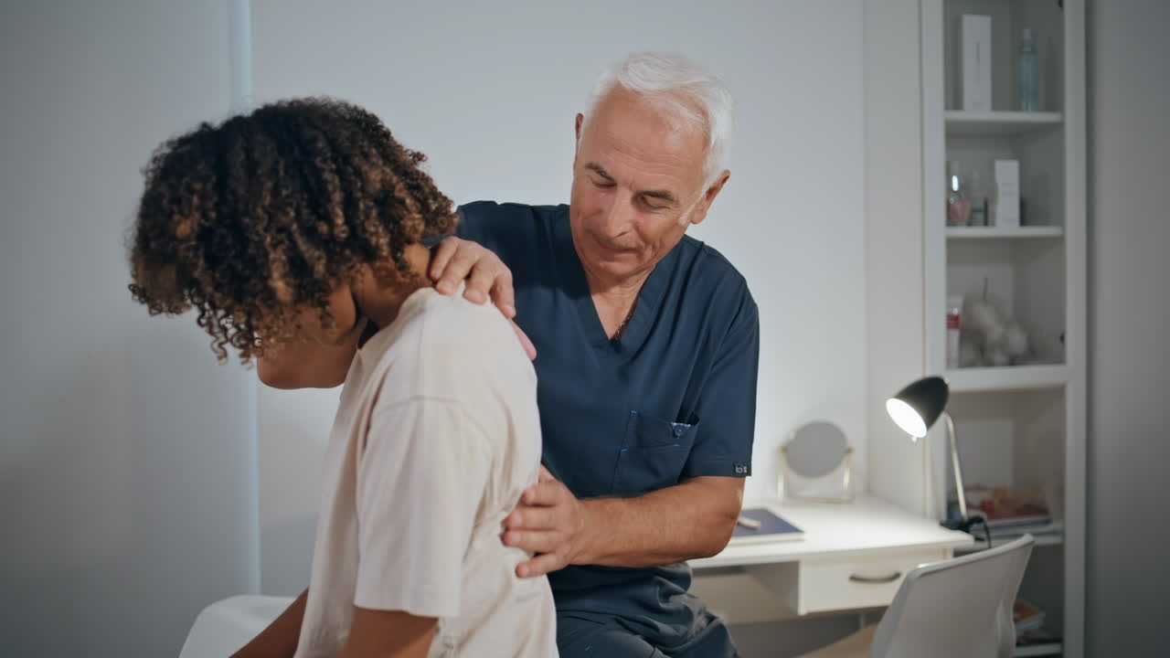 Physiotherapist checking patient back on session. Doctor examine spine problem