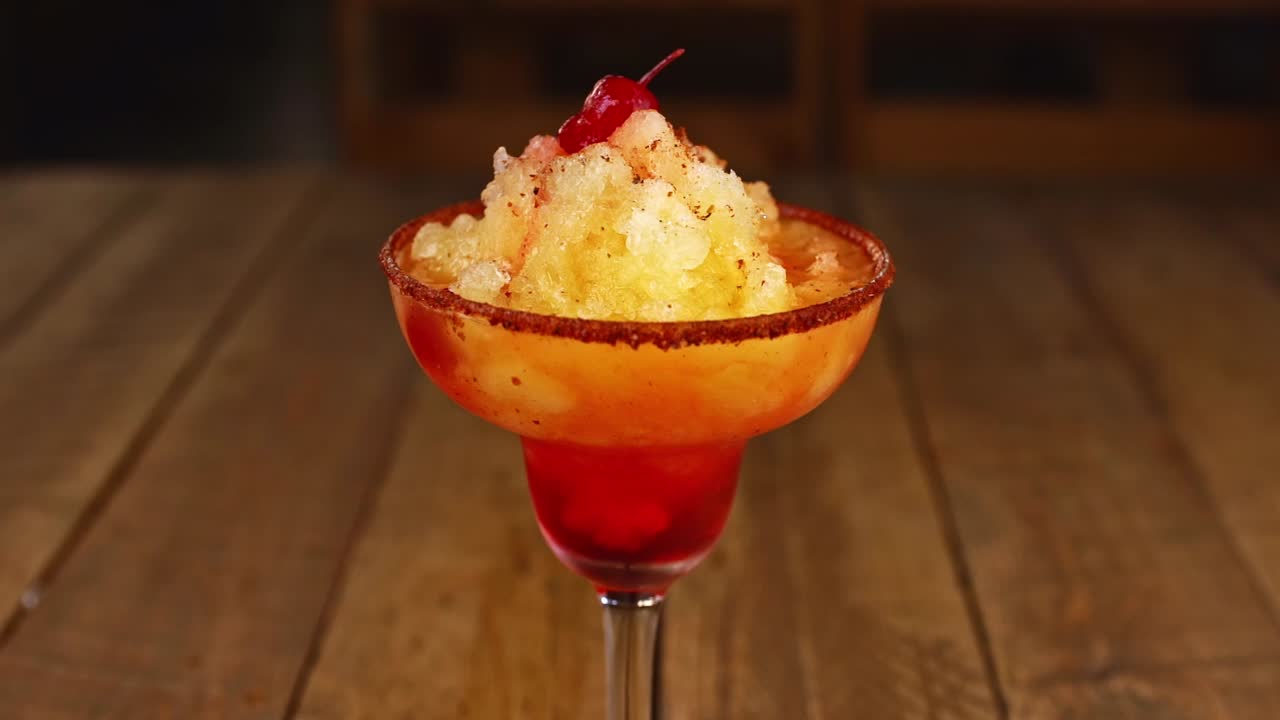 파인애플 아이스크림, 칠리 가루, 보드카를 나무 테이블에 넣은 칵테일을 제공하는 웨이터