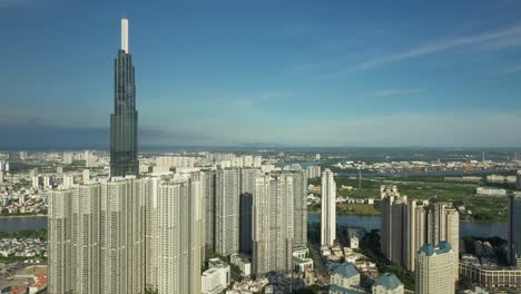 toma aérea de una grúa desde el distrito de binh thanh mirando hacia los desarrollos modernos y cruzando el río saigón hasta el segundo distrito de la ciudad de ho chi minh, vietnam, en una hermosa tarde clara y soleada.