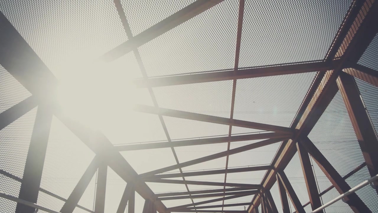 Geometric Metal Bridge Structure with Bright Sun and Lens Flare