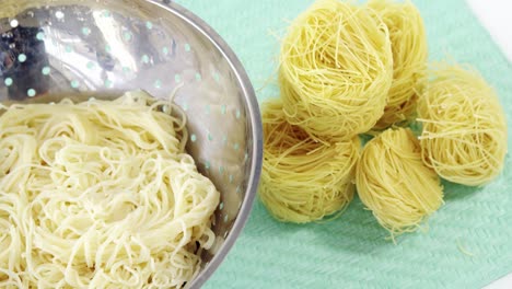 boiled pasta in colander with spaghetti rolls