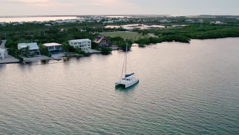 aerial, a sailboat anchored off the coast at sunset, florida keys