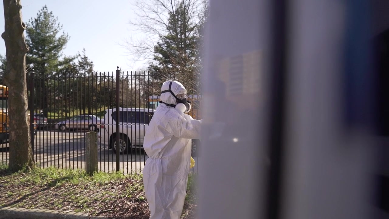 Squadra di specialisti per la disinfezione a spruzzo dell'epidemia di coronavirus. Pulizia del mondo con tute protettive