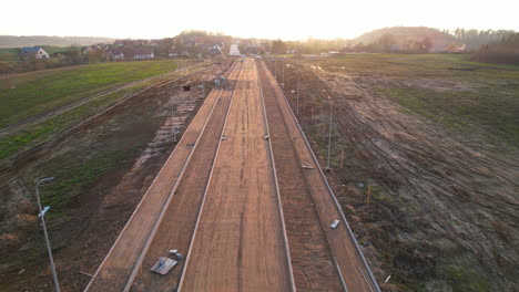 carretilla aérea sobre el sitio de construcción de carreteras al atardecer en el campo