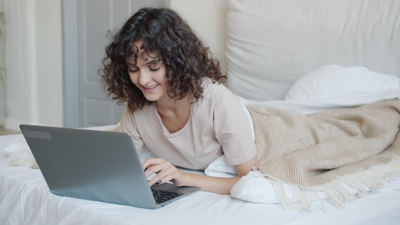 Woman working on a laptop in bed