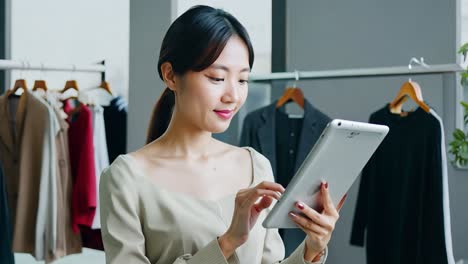 woman using tablet in fashion store