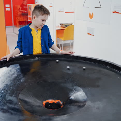 boy in the museum science. gravitational field model of black hole