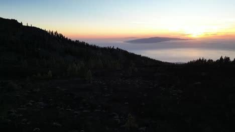 Campo-De-Lava-De-La-Cresta-Del-Volcán-El-Teide-Al-Atardecer-Con-El-Océano-Atlántico-Debajo,-Tenerife-Islas-Canarias-España,-Tiro-De-Descenso-Aéreo