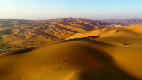 aerial view of a man sitting on the edge of dunes, u.a.e.