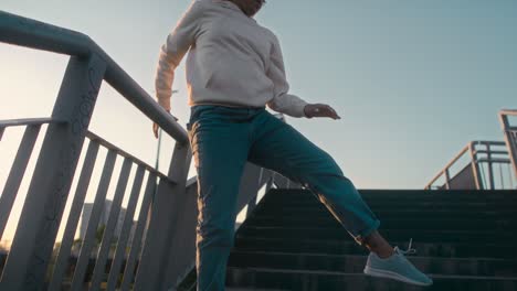 vista de ángulo bajo de mujer negra bailando en el puente y mirando a la cámara.