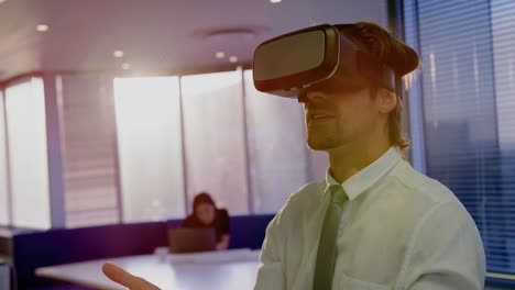 Front view of young Caucasian male executive using virtual reality headset in modern office 4k