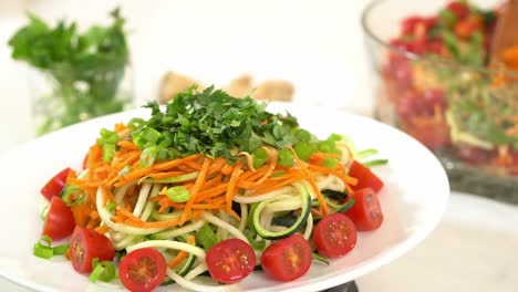 plated zucchini noodles on lazy susan rotating platter garnished cilantro