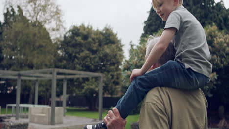 a boy enjoys a piggyback ride on a man's shoulders in a garden