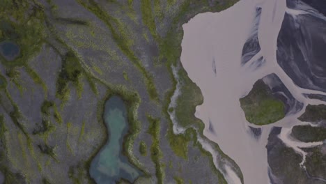 fotografía aérea de arriba hacia abajo de un río glacial en el paisaje volcánico de islandia en un día nublado - sobrevuelo
