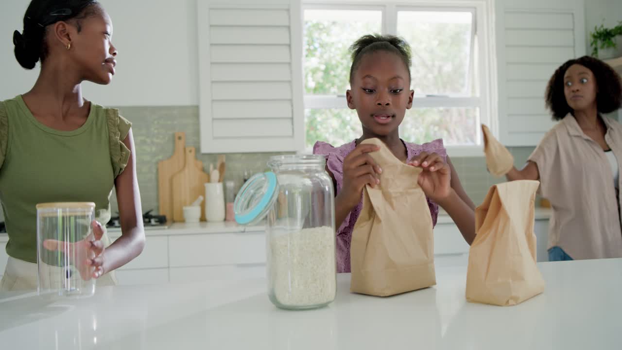 Girl receiving bags from mother in kitchen, sealing bags by jar and clear containers for pantry