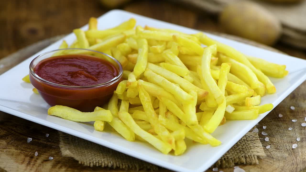 porción de patatas fritas recién hechas en un plato giratorio (loopable sin costuras)