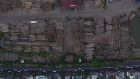 Timber-waiting-to-be-exported-at-port-area-along-the-Saigon-river-in-Ho-Chi-Minh-City,-Vietnam