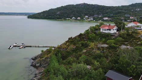 The-Wonderful-Mountainous-Community-In-Rörtången,-Sweden-Surrounded-With-A-Quiet-Ocean-Under-The-Cloudy-Sky---Aerial-Shot