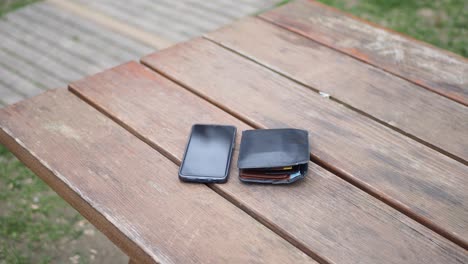 smartphone and wallet on wooden table