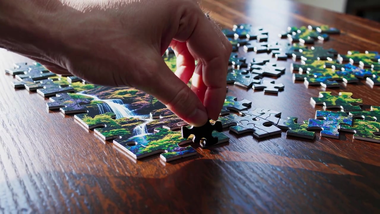 Primo piano di una mano che risolve un puzzle con un paesaggio naturale