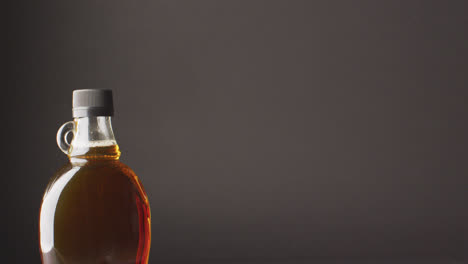 Video-of-maple-syrup-in-bottle-on-grey-surface