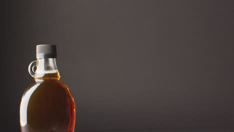 video of maple syrup in bottle on grey surface