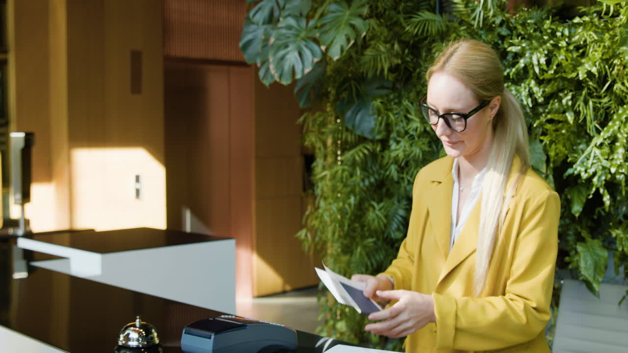 은 머리 여성 손님이 리셉션에 가방을 들고