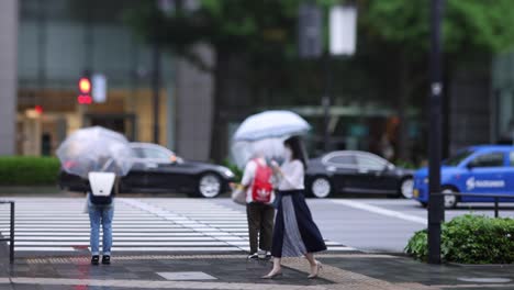 walking people on the street in marunouchi tokyo rainy day