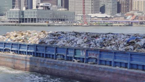Trash-barge-transporting-solid-waste-on-East-river-in-New-York,-USA
