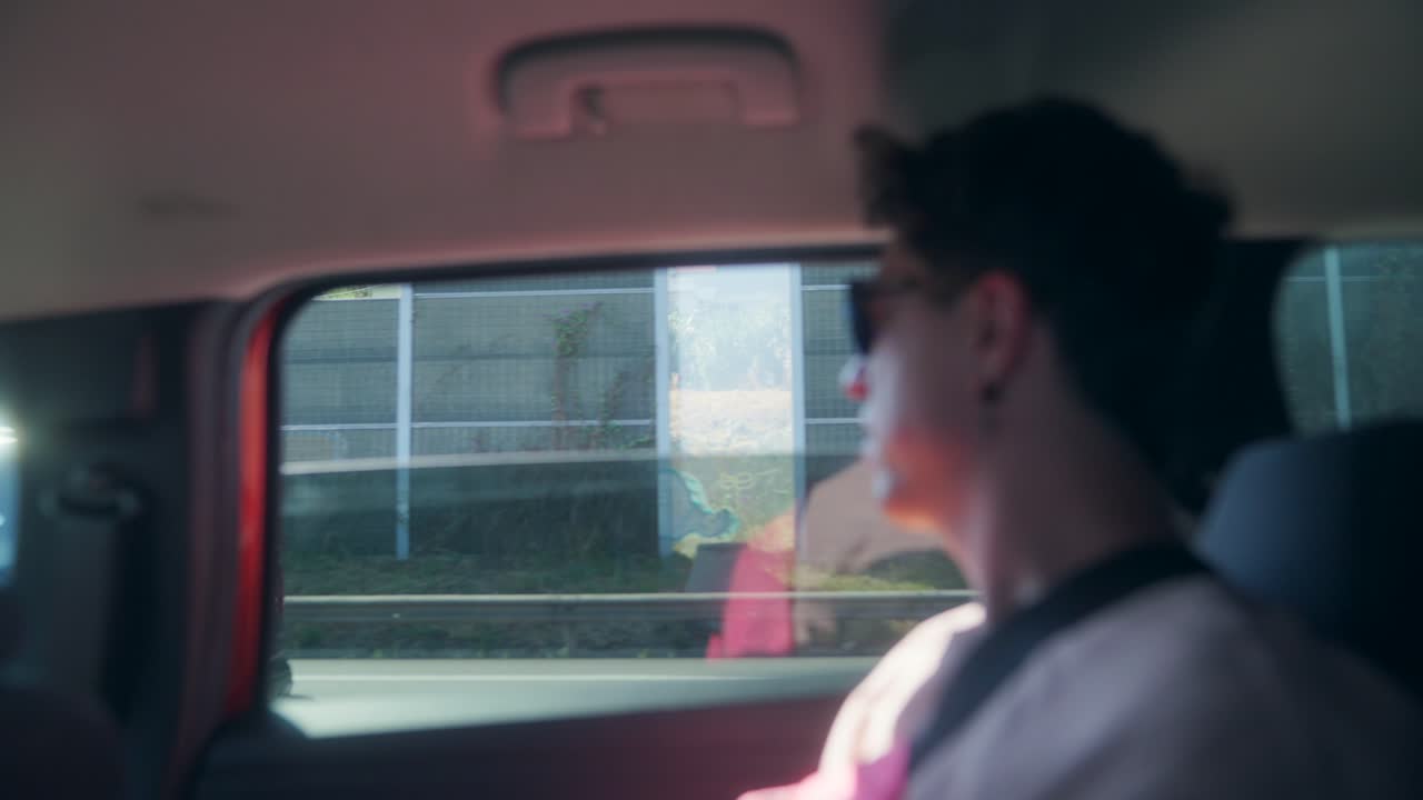 Person looking out the car window while driving