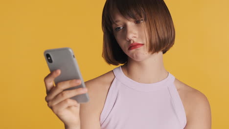 bored and upset young woman with red lips watching at the phone