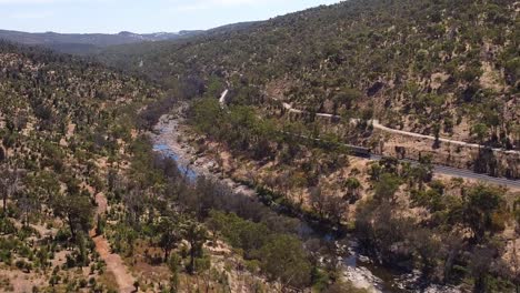 cinematic aerial view of passenger train winding through perth hills at bells rapids