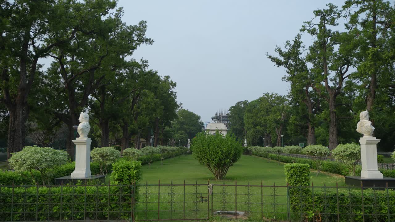A serene park avenue with statues and lush greenery