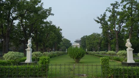 a serene park avenue with statues and lush greenery