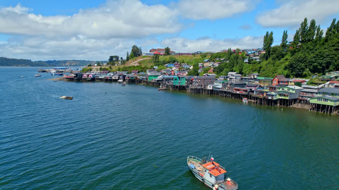 coloridas casas de pilotes de castro en la isla de chiloe con un crucero en barco, vista aérea
