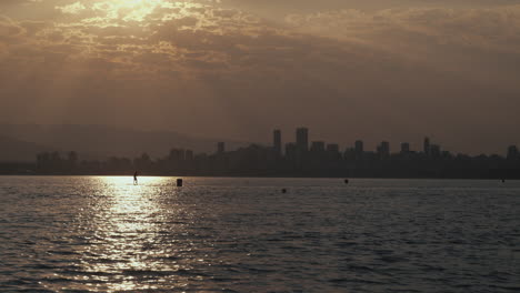 paddle surf de hombre con el fondo del horizonte de vancouver