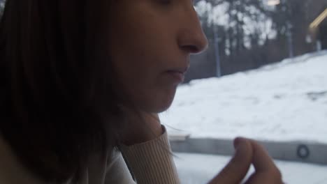 chica moja una galleta en café dentro de un café en un día de invierno cerrado