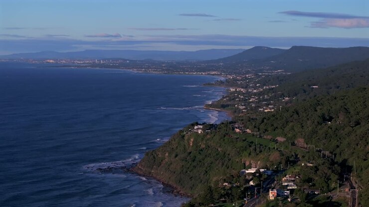 Unique aerial drone perspective South Coast Wollongong Australia University coastline Coalcliff train station Throull Coal Mining Grand Pacific Drive sunny morning spring summer Tasman sea blue sky