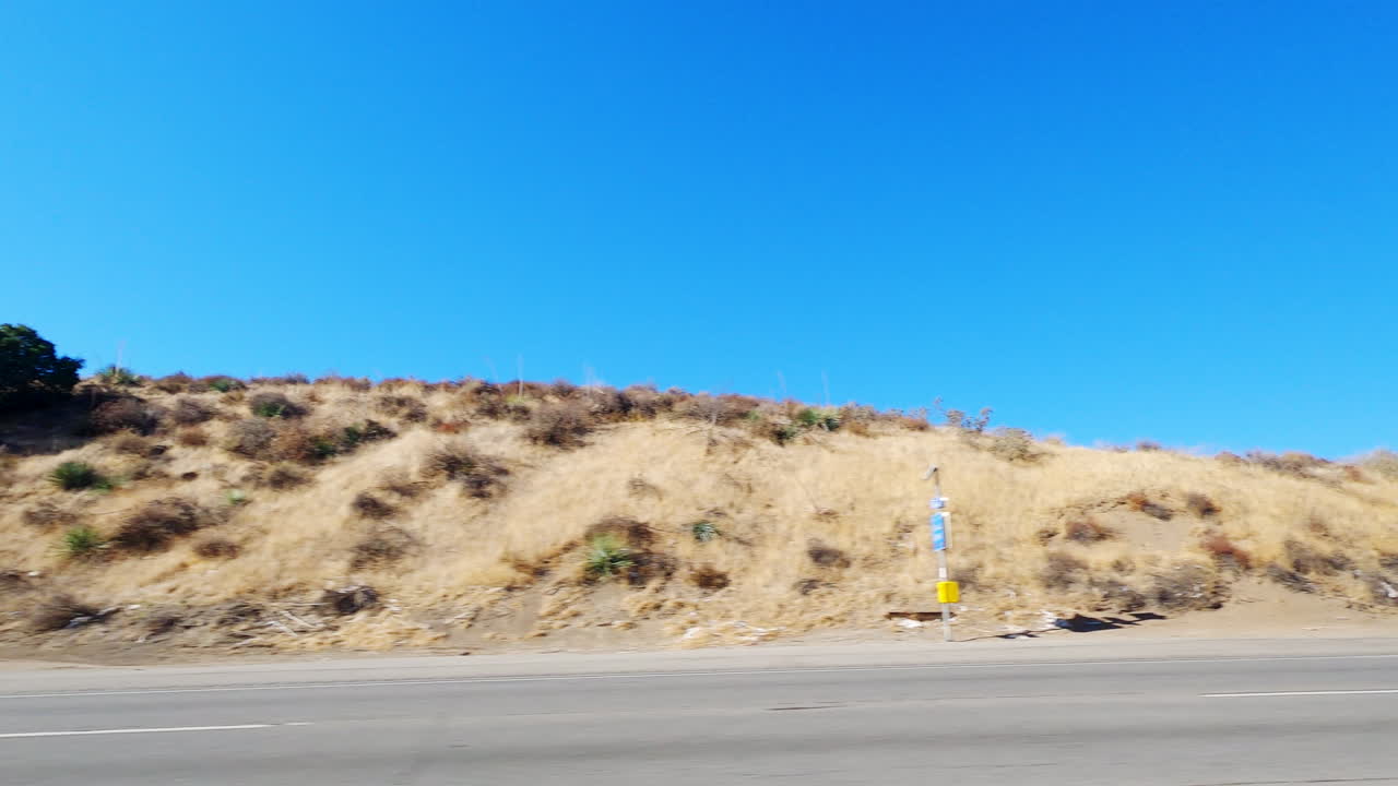 푸른 하늘이 있는 산악 고속도로에서 빨간색과 흰색 세미트럭을 지나서 운전하다